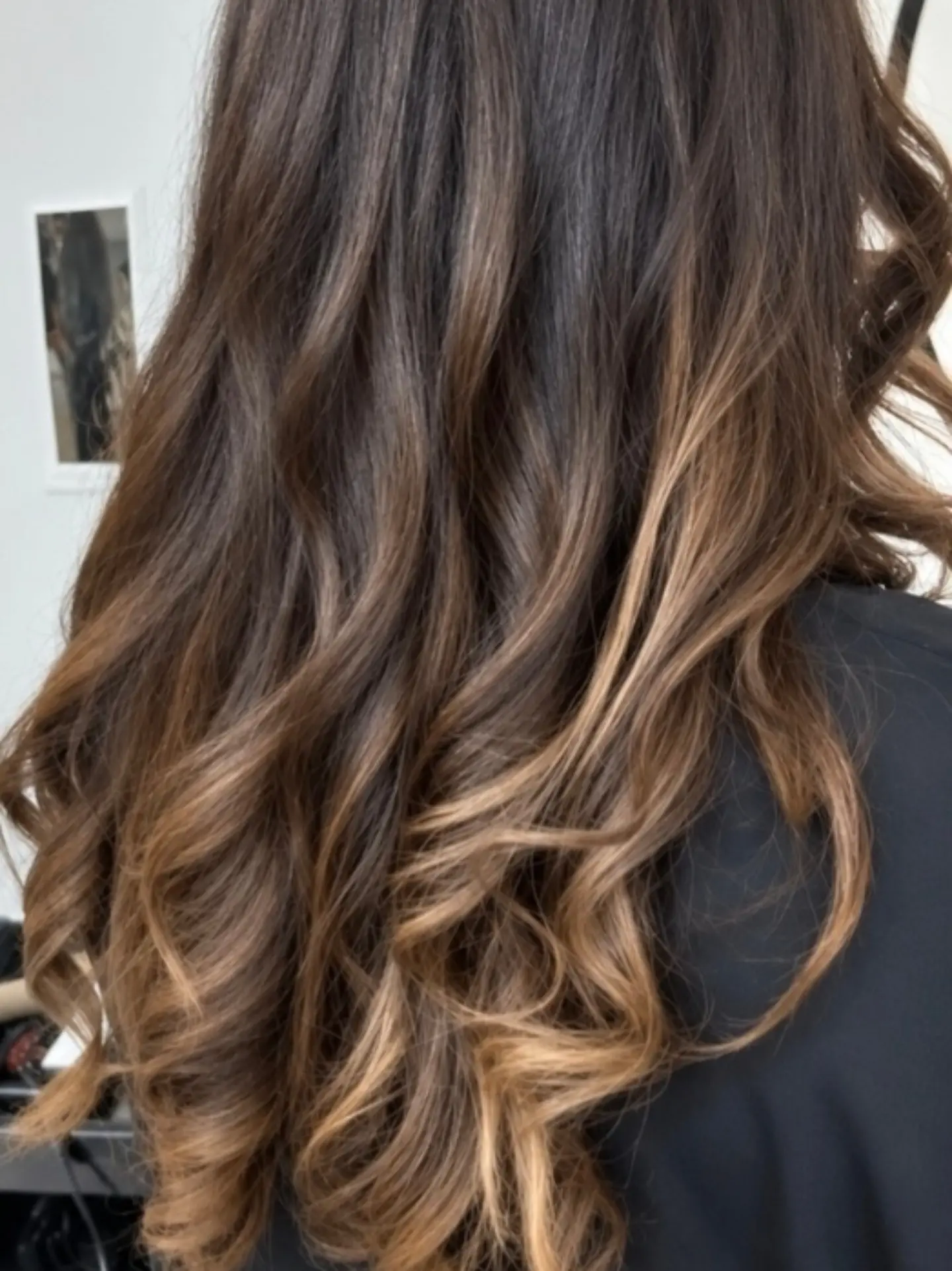 Bruin haar met karamelkleurige balayage in de punten, in losse golven